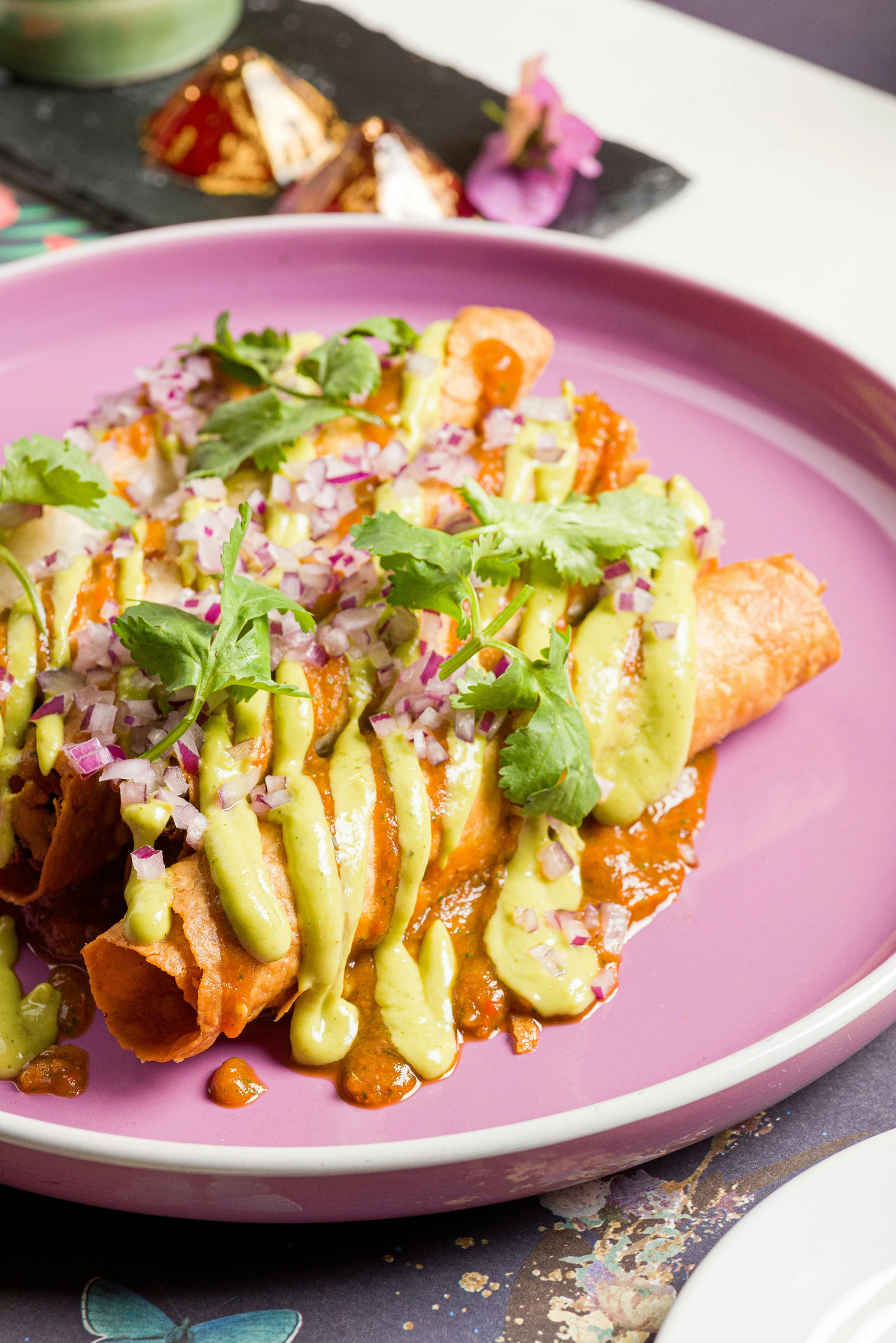 Loaded rolled tacos topped with fresh garnishes
